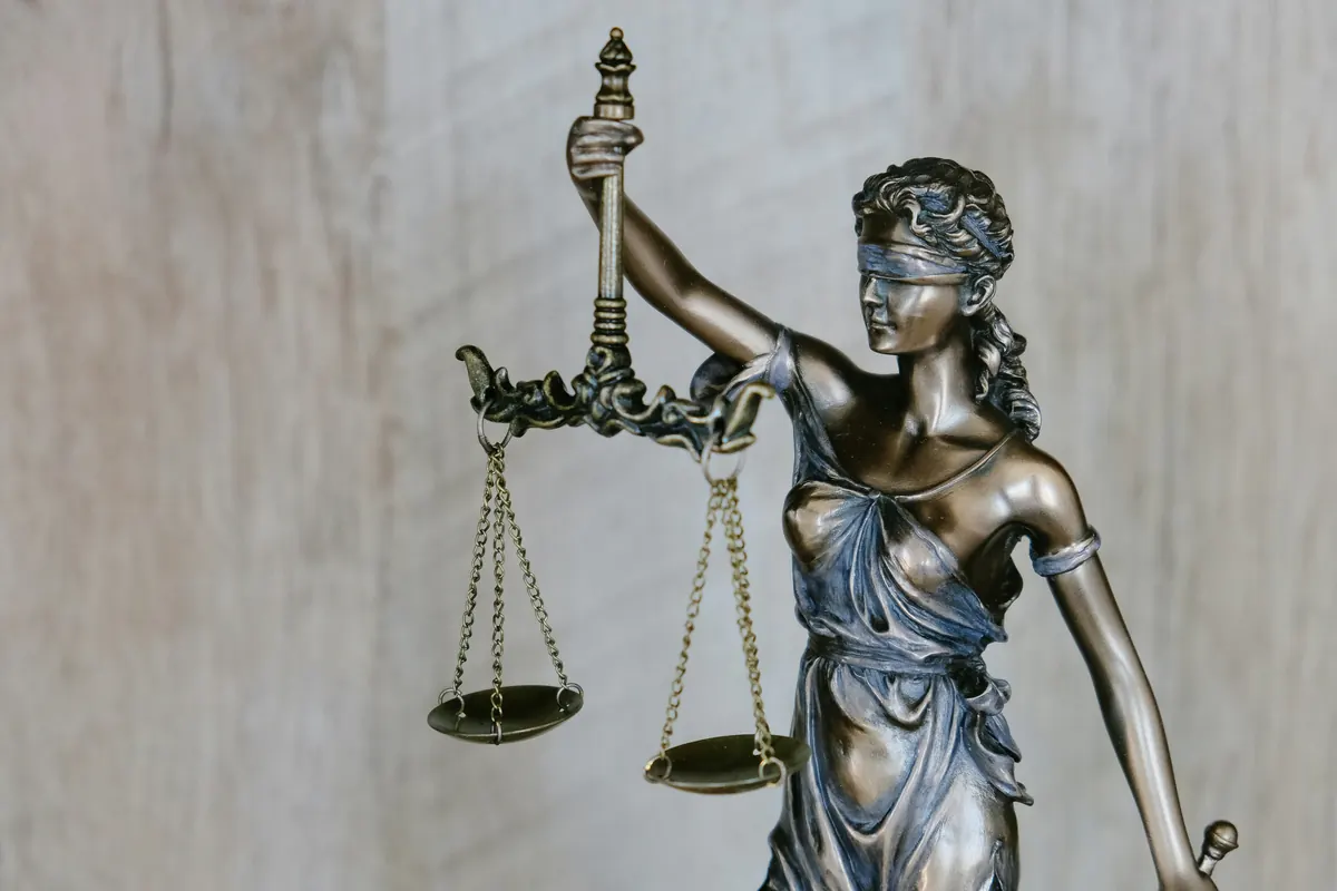 Estátua da Justiça sobre mesa de escritório